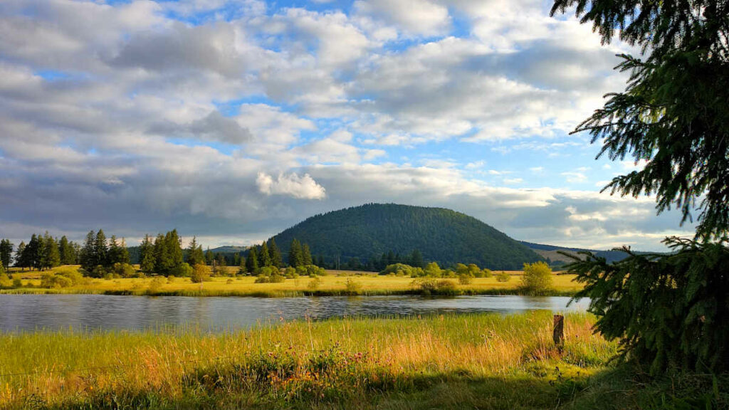 Tourbière et lac de Bourdouze au coucher du soleil. Puy de Montcineyre en arrière-plan. Massif des Monts-Dore, Puy-de-Dôme, Auvergne.